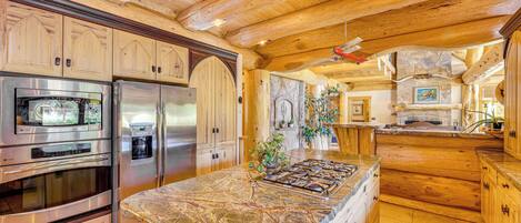 A spacious kitchen with wooden cabinets, stainless steel appliances, and a large island.
