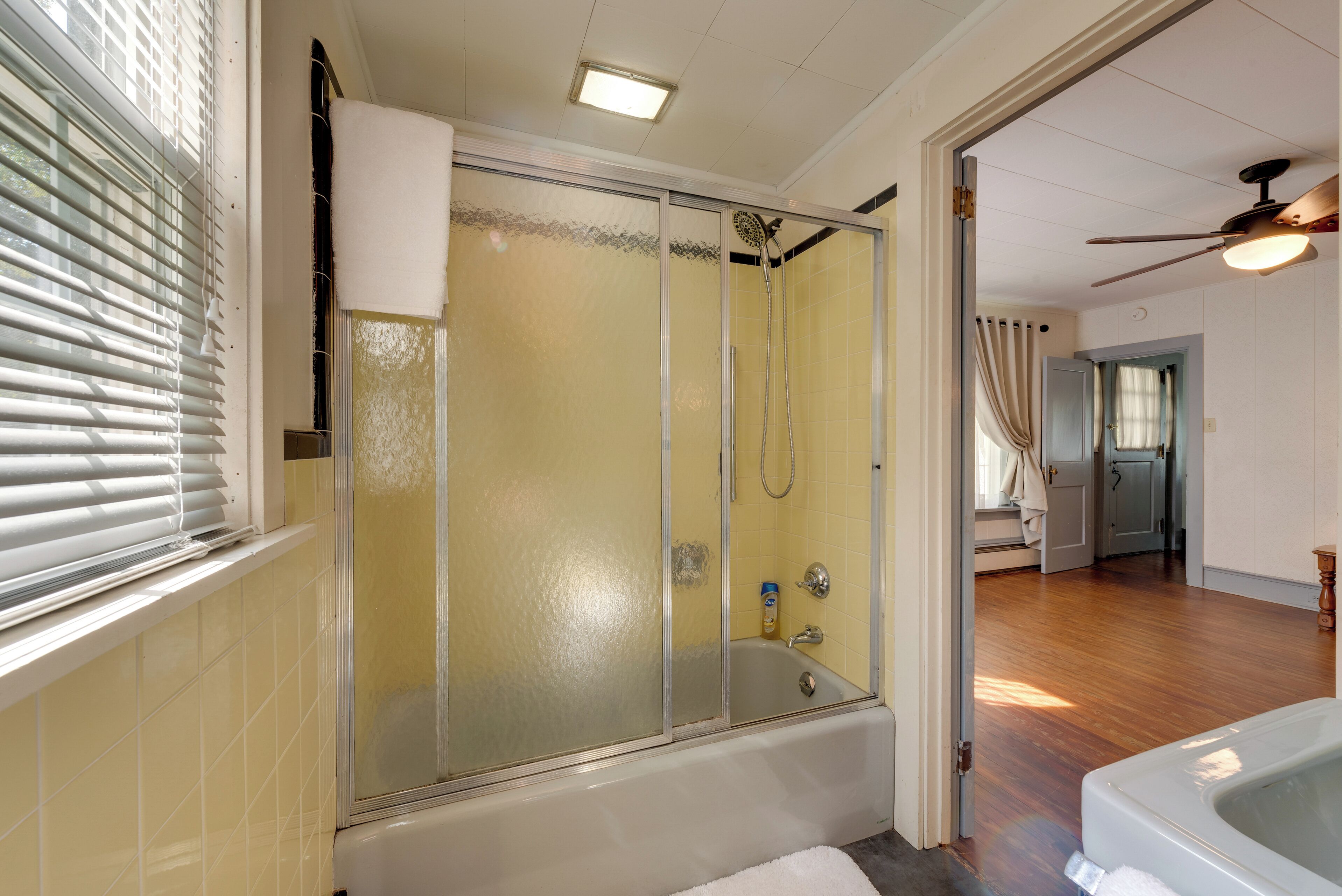 A bathroom with a glass-enclosed shower, a bathtub, and a toilet.