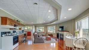 A spacious living area with a kitchen, wooden flooring, and large windows. - 'holmes With a View' Studio: Millersburg Retreat! (Millersburg)