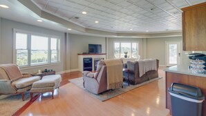A spacious living room with hardwood floors, a large window, a fireplace, and a television. - 'holmes With a View' Studio: Millersburg Retreat! (Millersburg)
