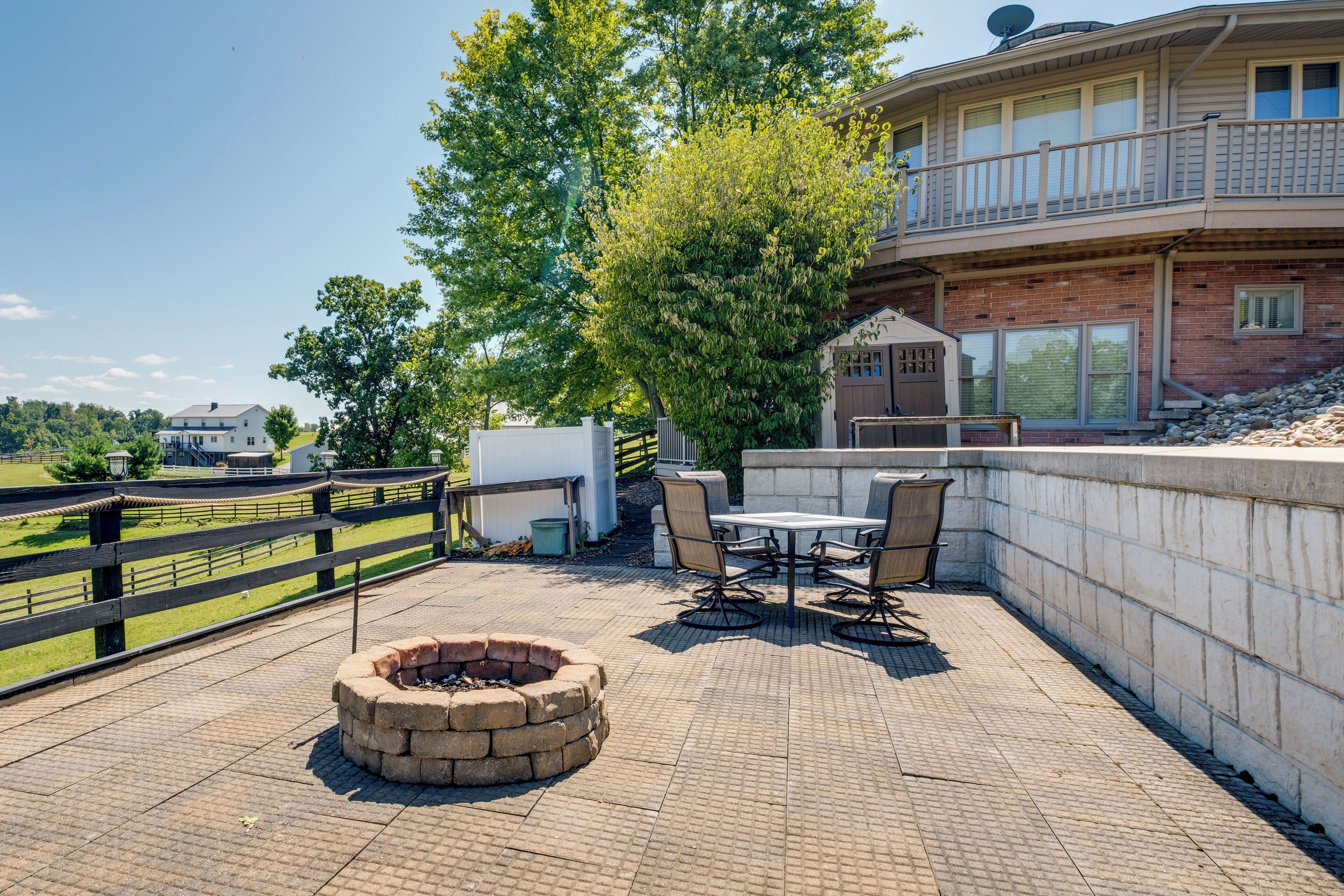 A patio area with a fire pit, outdoor furniture, and a view of a residential building.