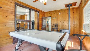 A pool table in a wooden room with a ceiling fan, a mirror, and a door leading to another room. - Family-friendly Albuquerque Home Near Rio Grande! (Albuquerque)