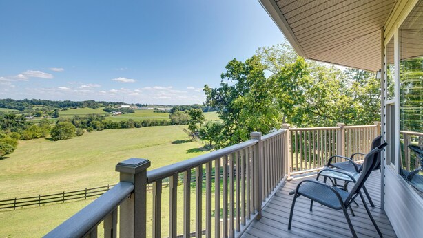 A wooden deck with a railing overlooking a green landscape. - Millersburg Getaway w/ Amish Country Views! (Millersburg)