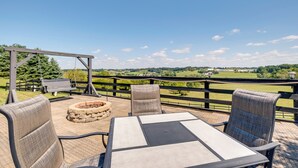 An outdoor patio with a table and chairs, a swing set, and a view of a green landscape. - Millersburg Getaway w/ Amish Country Views! (Millersburg)