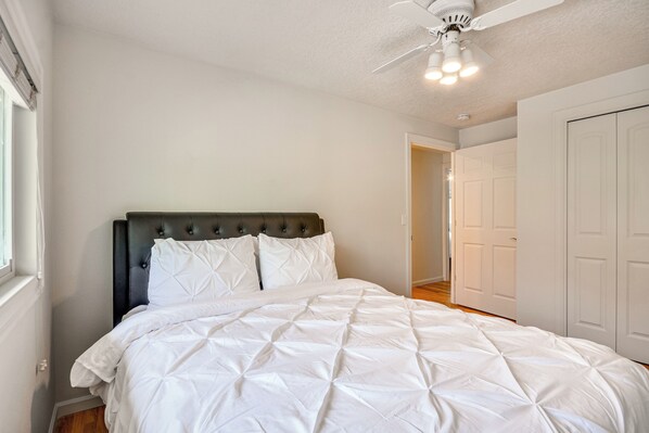 A bedroom with a bed, a ceiling fan, and white doors. - Milwaukie Home w/ Outdoor Dining Space (Milwaukie)