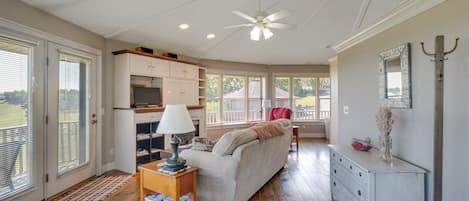 A spacious living room with a sofa, a coffee table, and a ceiling fan.