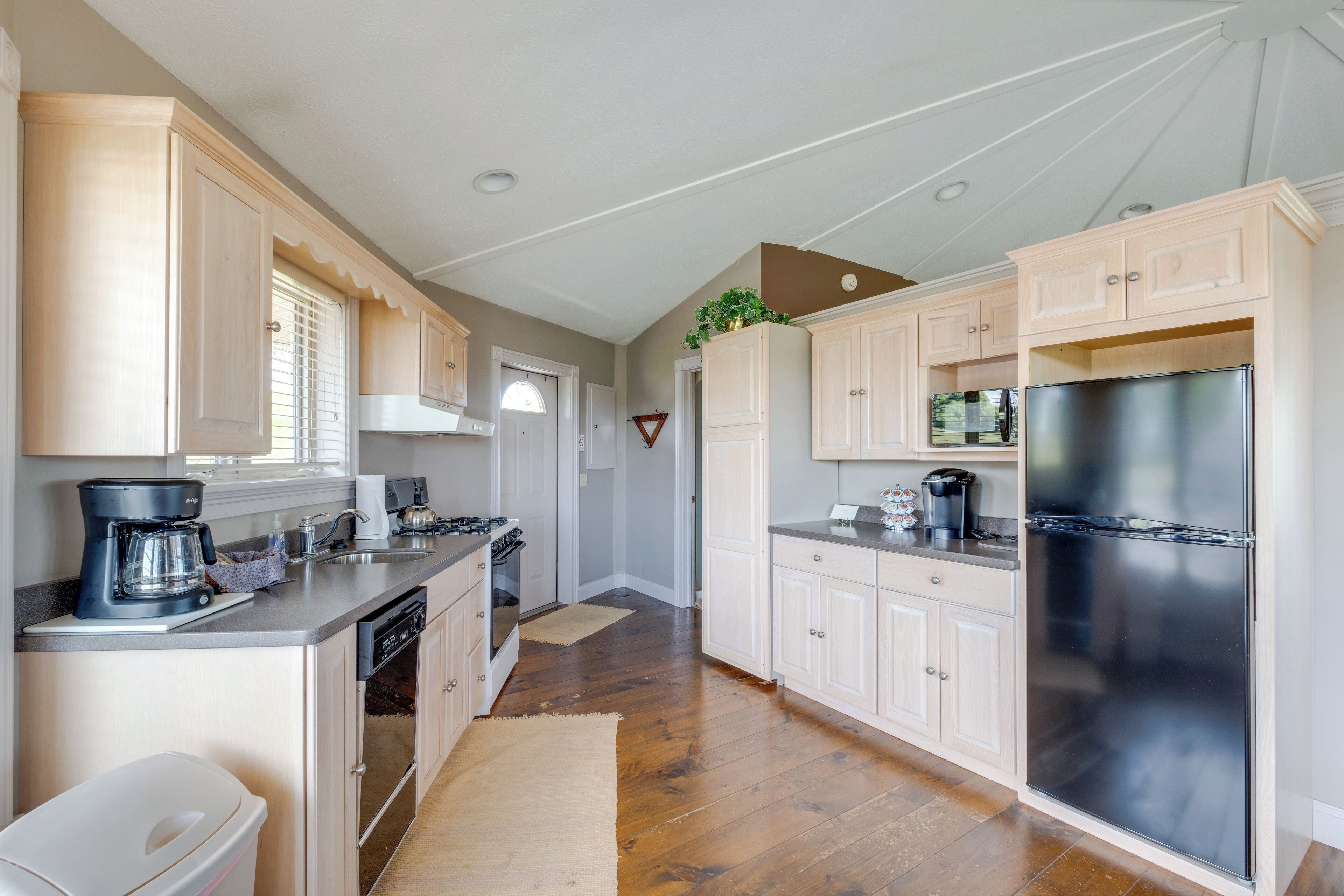A kitchen with wooden cabinets, a stainless steel refrigerator, and a coffee maker.
