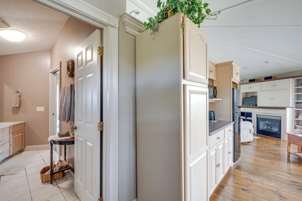 A modern kitchen with white cabinetry, a wooden floor, and a built-in microwave. - Panoramic Views: Hillside Millersburg Studio (Millersburg)