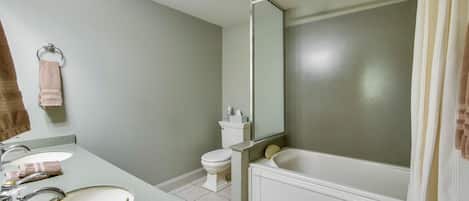 A bathroom with a sink, toilet, and bathtub.
