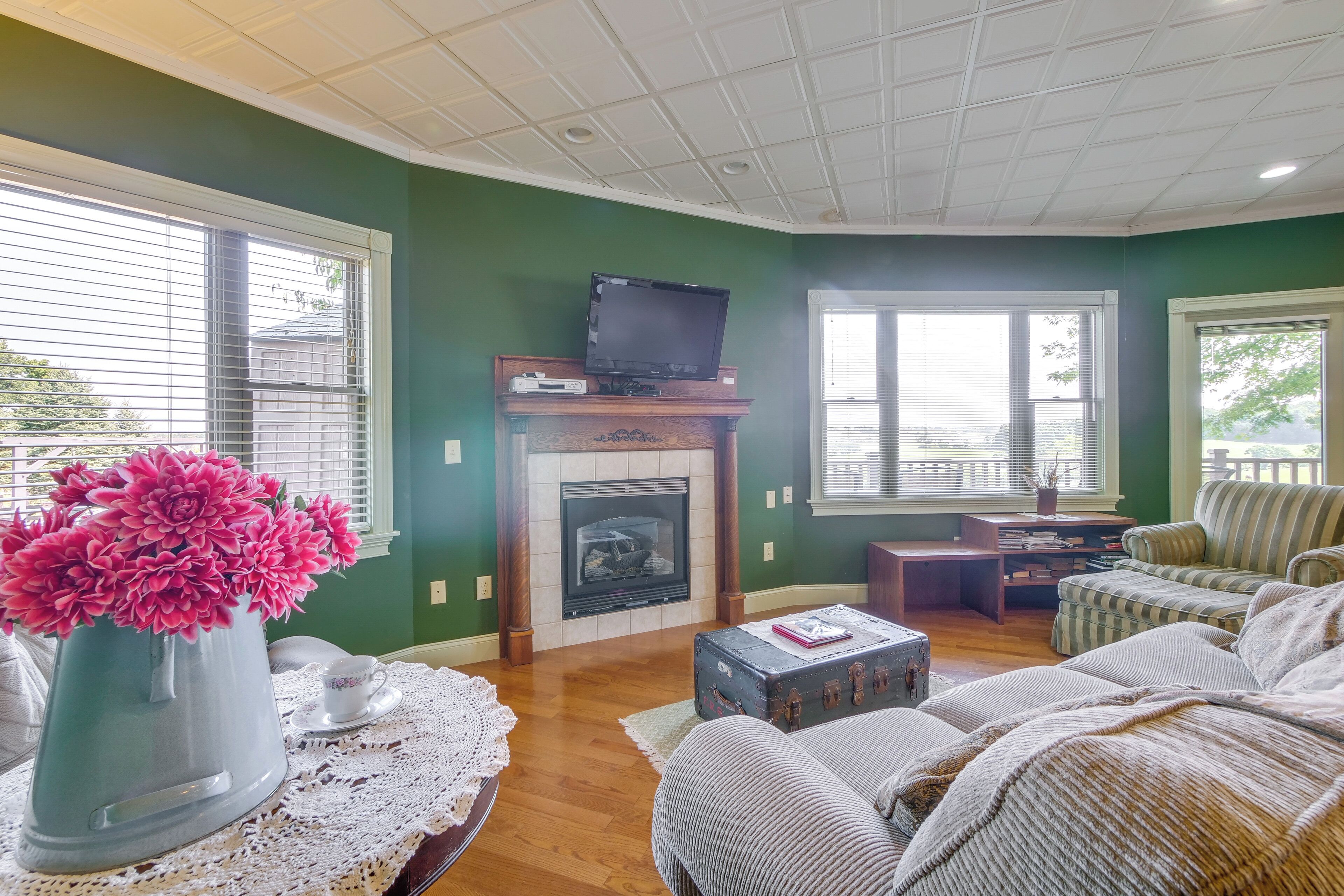 A living room with a fireplace, a television on a mantel, a sofa, and a coffee table.