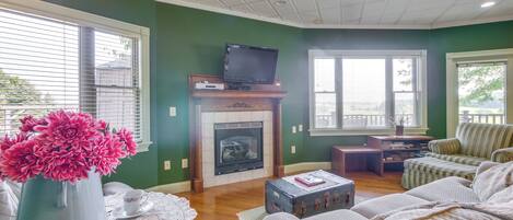 A living room with a fireplace, a television on a mantel, a sofa, and a coffee table.