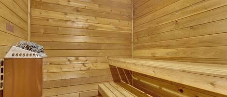A wooden sauna with benches and a heater.