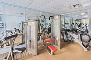 A gym with various exercise machines, including treadmills and weight stations. - 6165 Carrier Drive #1001 (Orlando)