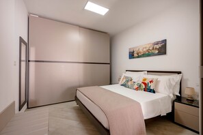 Une chambre à coucher avec un lit, une table de chevet et un tableau accroché au mur.