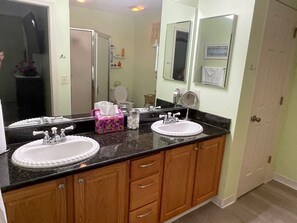 A bathroom with two sinks, a mirror, and a toilet.