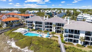 Un hôtel situé sur la côte, doté d’une grande piscine, de plusieurs bâtiments et offrant une vue sur la plage.