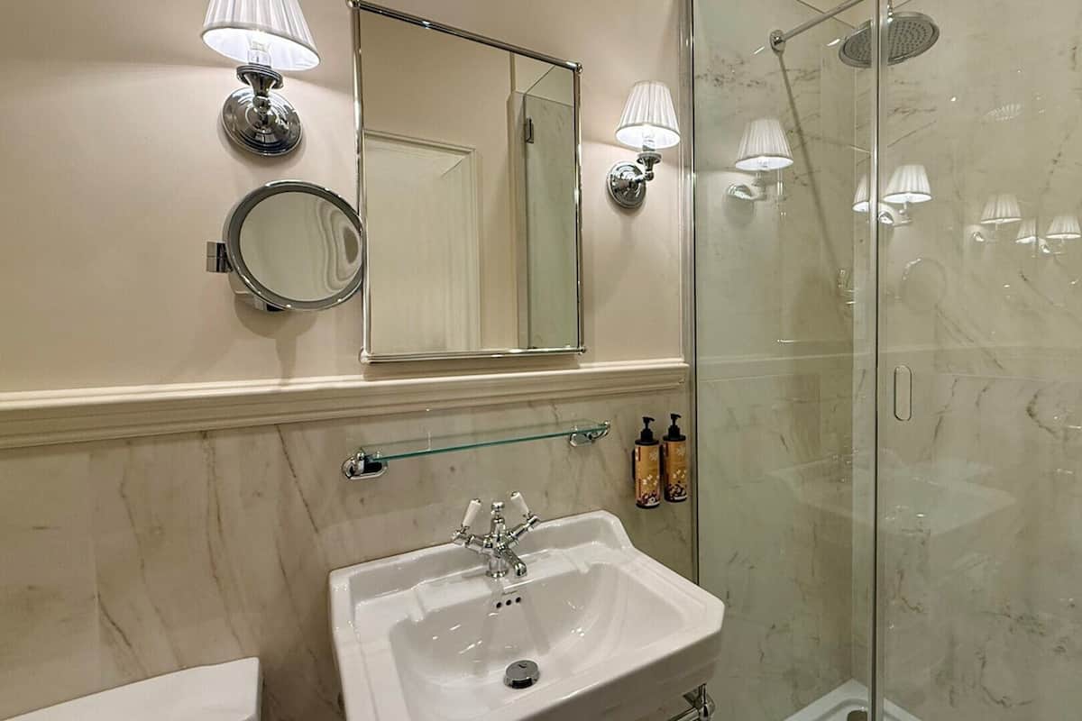 Ein Badezimmer mit Waschbecken, Spiegel und Dusche.