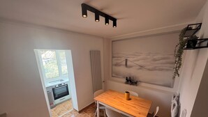 Una cocina moderna con una mesa y sillas de madera, un ventanal y una obra de arte colgada en la pared.