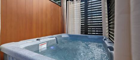 Un jacuzzi con pared de madera y ventana.