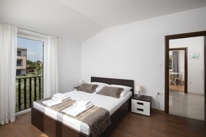 A bedroom with a bed, bedside tables, a window with curtains, and a view of a balcony. - Apartments Heidi with shared Pool (Ap 2) (Nova Vas)