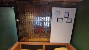 A single bed with a yellow bedspread and pillows, a wooden headboard, and a whiteboard with framed pictures on the wall. - Tiny wellness room  in Nieuwegein near Utrecht (Nieuwegein)