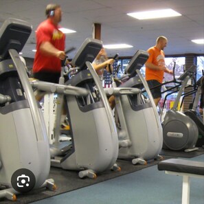 Une salle de sport équipée de tapis de course et d’appareils de musculation elliptique.