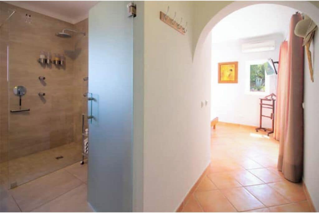 A bathroom with a shower, a toilet, and a sink.