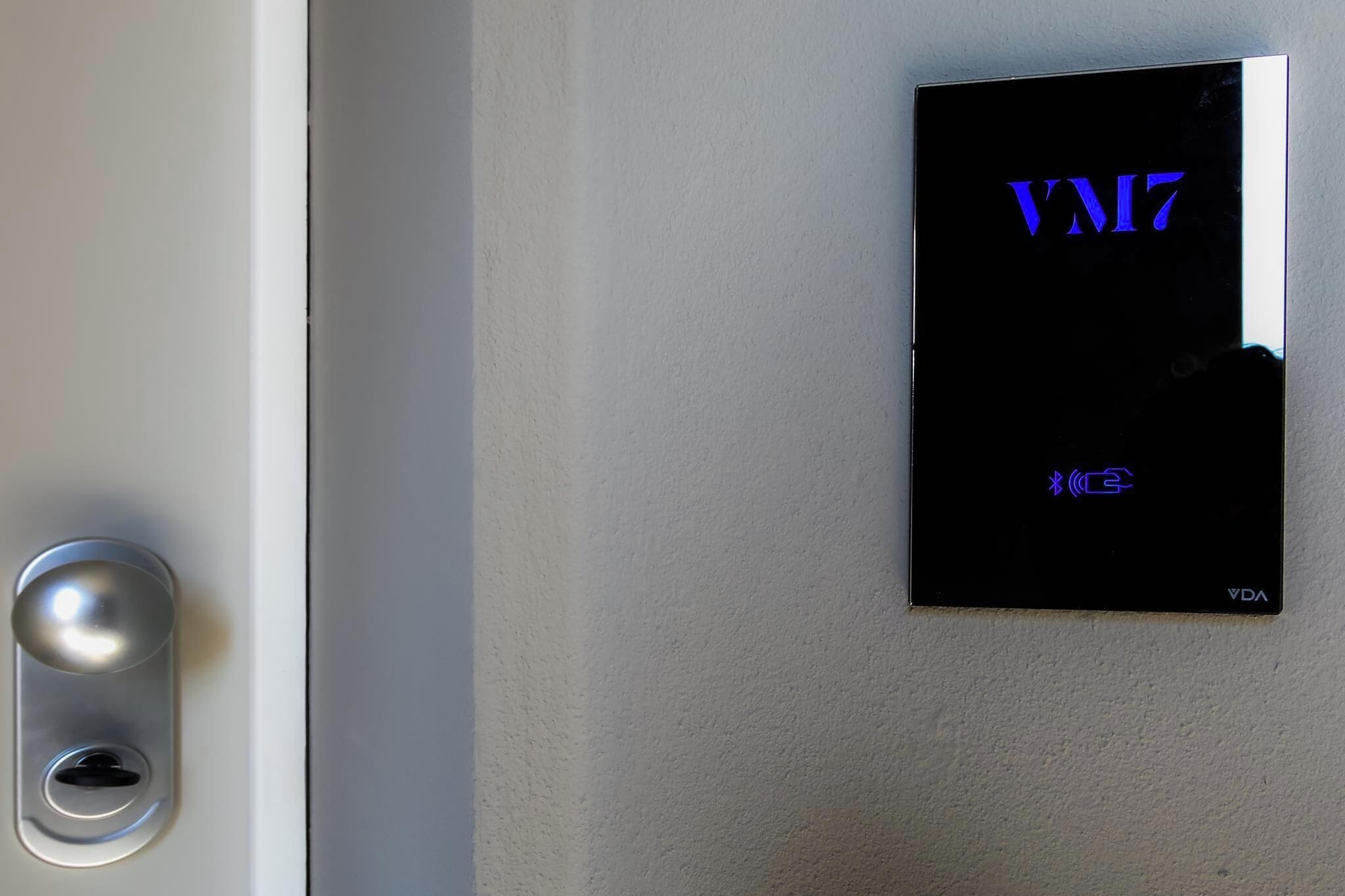 A digital lock and a wall-mounted device displaying "VM17" and "VDA".