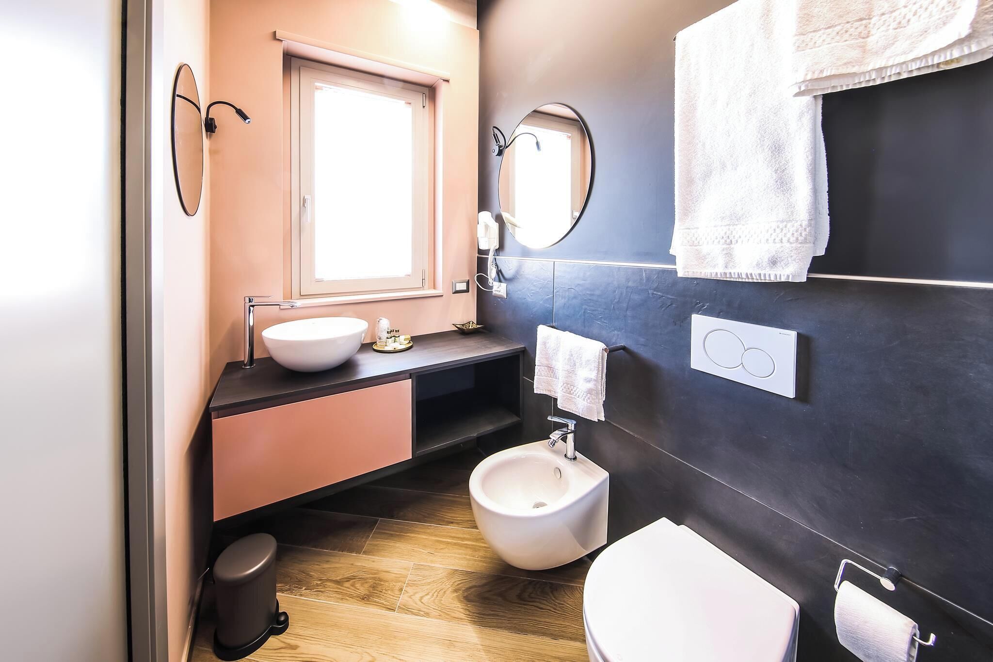 A modern bathroom with a sink, bidet, and toilet.