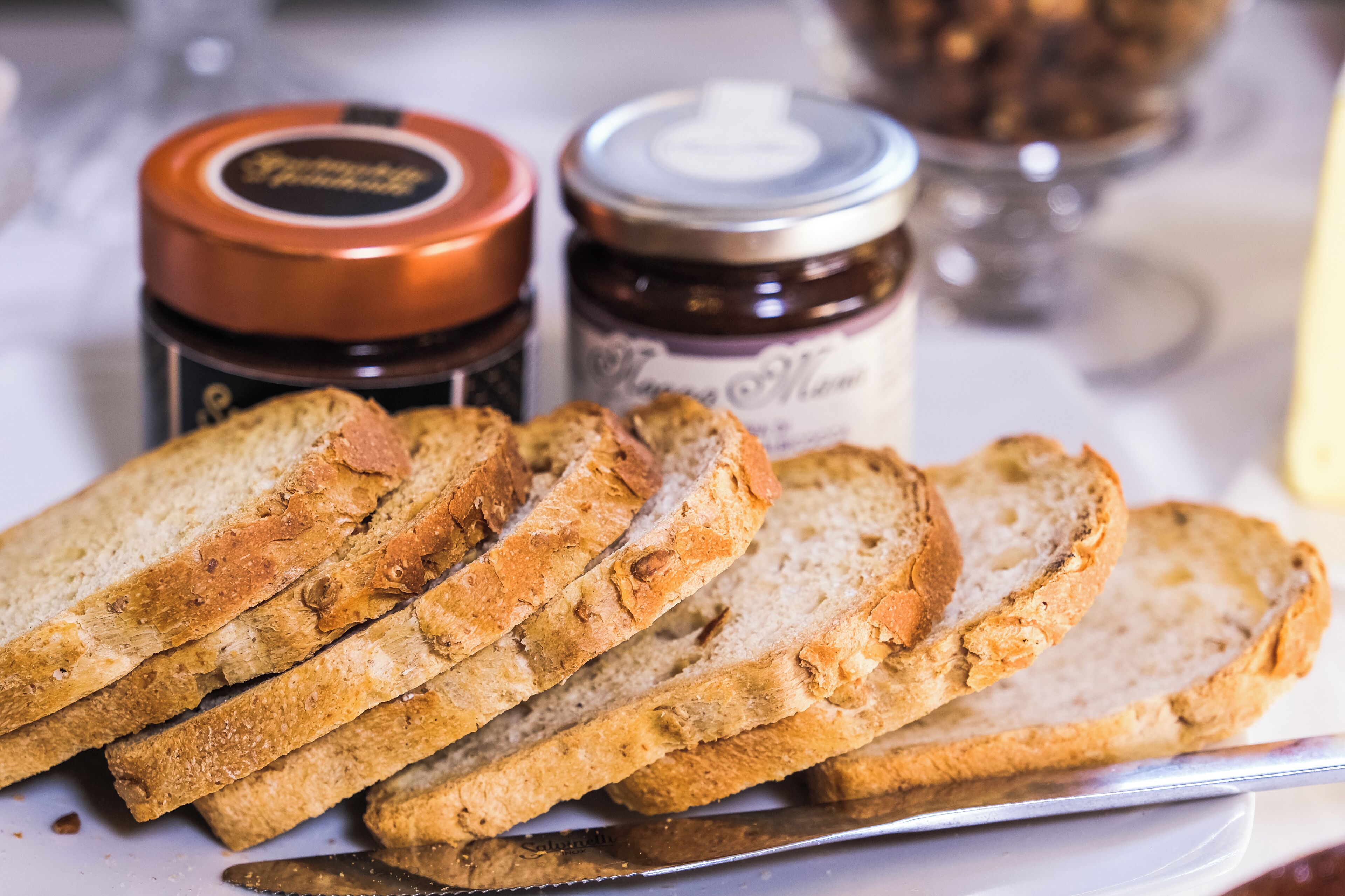 Sliced bread and two jars of preserves on a tray.