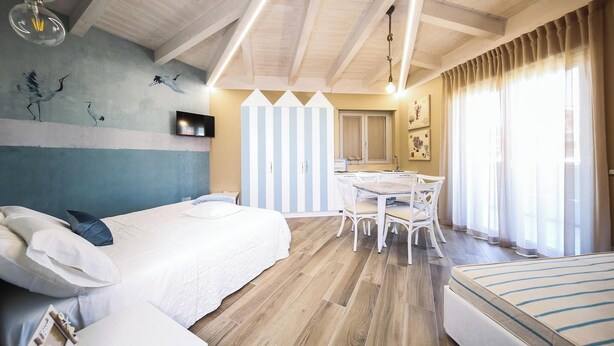 Un dormitorio con cama, mesita de noche y un pequeño escritorio con silla.