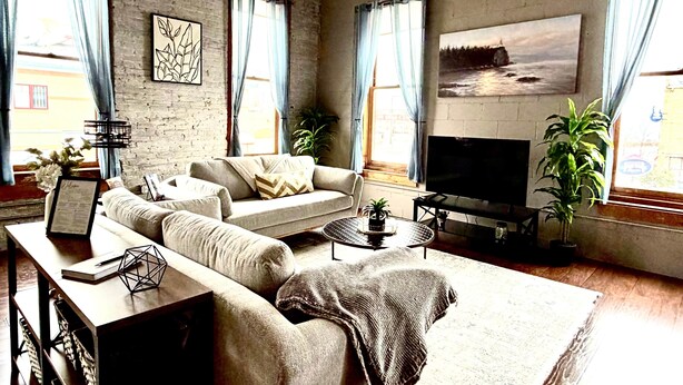 Ein Wohnzimmer mit Sofa, Fernseher und Pflanzen.