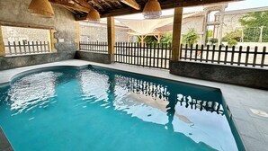 An indoor swimming pool with a wooden ceiling and hanging lamps. - Gite Alcea - Château de Panisseau (Thénac)