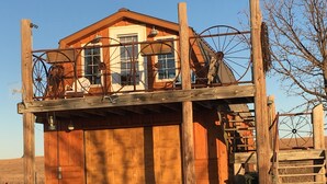 A wooden building with a garage and a covered porch area.
