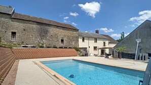 Una piscina con un edificio de piedra al fondo.