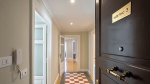 A hallway with a checkered floor, a door labeled "INterno 3", and a light switch on the wall. - Elegant, New, Spacious 3Bedroom Home Between Vatican, Piazza Navona & Trastevere (Roma)