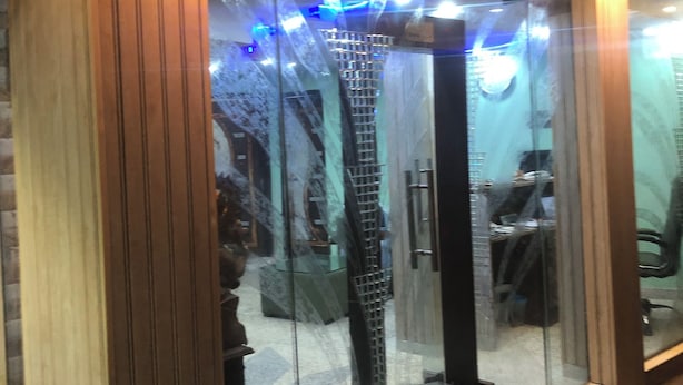 A glass-enclosed elevator with a metal spiral staircase inside. - Hotel Darpan Palace (New Delhi)