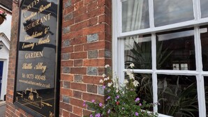 A brick building with a signboard advertising a restaurant, garden, and contact information. - Royal Oak Retreat - Sleeps 6, Pub & Pet Friendly (Lewes)