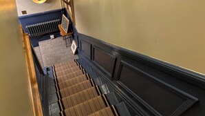 A staircase with a patterned carpet, a radiator, and a framed picture on a stand. - Royal Oak Retreat - Sleeps 6, Pub & Pet Friendly (Lewes)