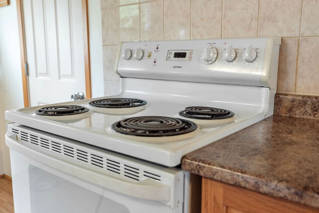 A white Hotpoint gas stove with four burners and a digital control panel.