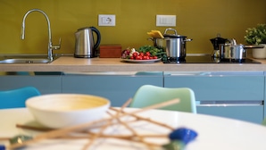 A kitchen with a sink, stove, and various cooking utensils. - HouSmart Emilia Levante 98 (Bologna)