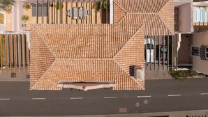 Un edificio moderno con fachada geométrica, entrada protegida y zona de estacionamiento.