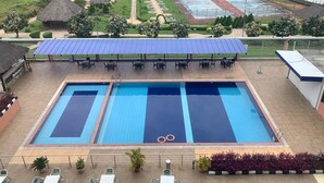A rooftop swimming pool with two lanes, surrounded by outdoor seating and a covered area with solar panels. - Agulu Lake Resort and Conference Centre (Adazi Nnukwu)