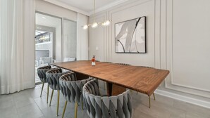 Un comedor moderno con una mesa de madera, sillas tapizadas en gris y una lámpara contemporánea.