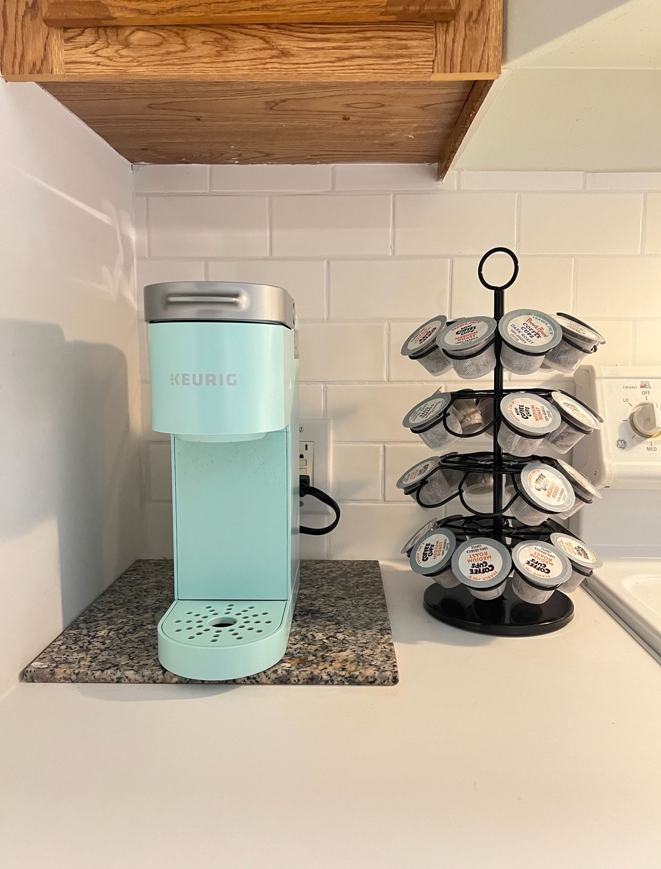 A kitchen with a Keurig coffee maker and a coffee mug holder.