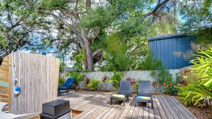 A wooden deck with lounge chairs and a hot tub.