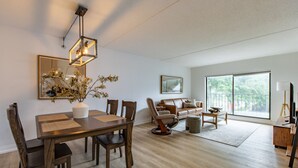 Un salon moderne avec un coin repas, de grandes fenêtres et un design minimaliste.