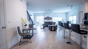 Una sala de estar amplia con comedor, cocina y zona de bar.
