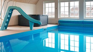 An indoor swimming pool with a blue slide, large windows, and a tiled ceiling. - 4 Star Holiday Home in Ulfborg (Ulfborg)