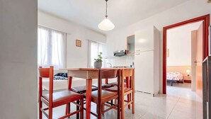 A compact hotel room with a dining area, a kitchenette, and a bed. - Holiday flat with air conditioning (Bibione)